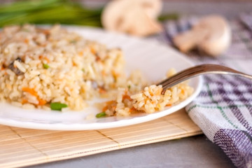 White plate with spicy pilaf with mushrooms