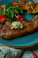 Steak with vegetables and salad, with roasted garlic