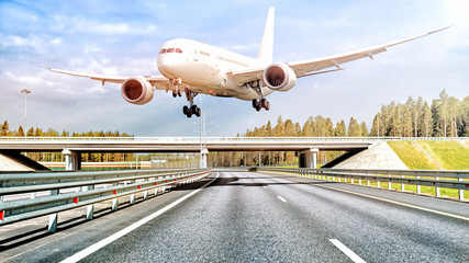 modern airplane flying low over freeway to airport driver person road car windshield view of...