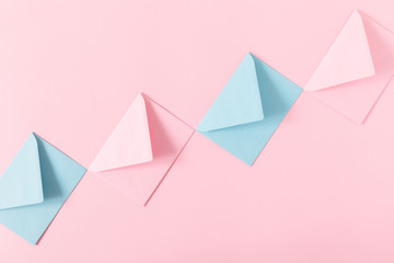 Romantic composition. Pink and blue envelopes on pink background. Flat lay, top view, copy space