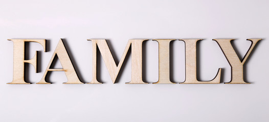 word "FAMILY" is made from wooden letters isolated on a white background