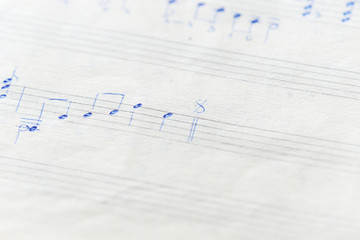 Fragment of an old musical notebook with hand written notes close up