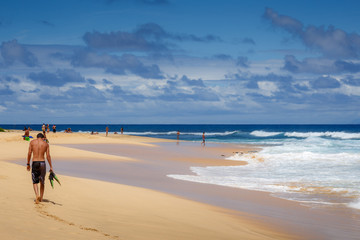 People enjoying a beautiful sandy beach and surf at Oahu, Hawaii in May 2015