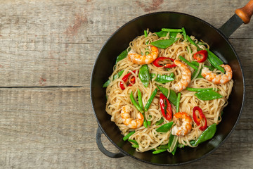 Asian dish of fried rice noodles with shrimp and vegetables. The view from the top. Copy-space.