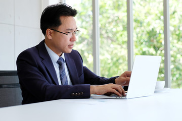 Asian businessman working with laptop computer at office, business concept