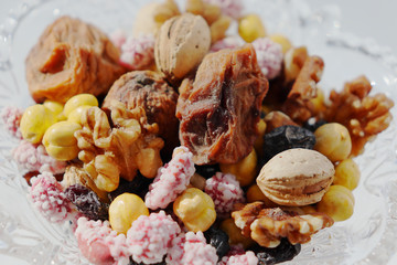 Sweet dried fruits and nuts in a crystal vase.