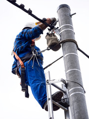 Praca montera instalacji elektrycznej na słupie energetycznym © JDziedzic