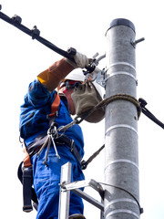 Praca montera instalacji elektrycznej na słupie energetycznym © JDziedzic