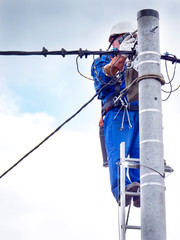 Praca montera instalacji elektrycznej na słupie energetycznym © JDziedzic