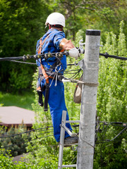 Praca montera instalacji elektrycznej na słupie energetycznym © JDziedzic