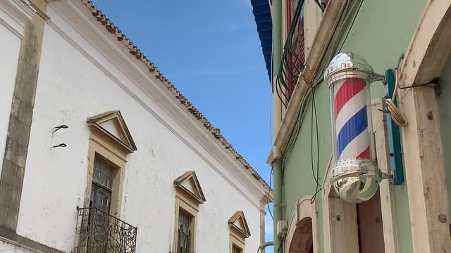 Rotating traditional barber shop pole in a European village with copy space