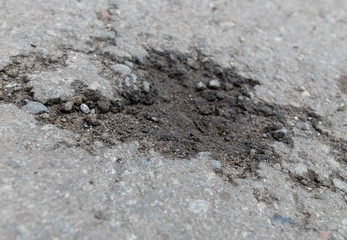 Cracks and pit on the asphalt road as background