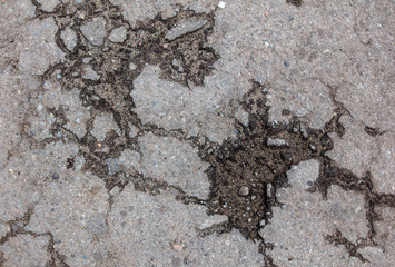 Cracks and pit on the asphalt road as background