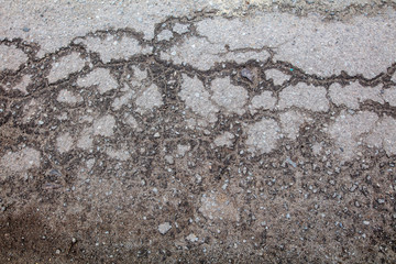 Cracks and pit on the asphalt road as background
