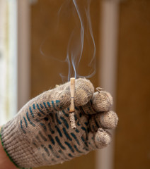 Cigarette in the hand of a worker at a construction site