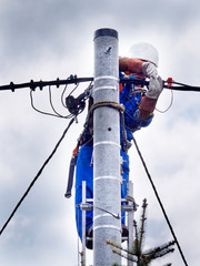 Praca montera instalacji elektrycznej na słupie energetycznym © JDziedzic