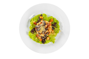 Salad with bread crumbs and prunes on lettuce, carrots, potatoes and mayonnaise on plate, white isolated background, view from above