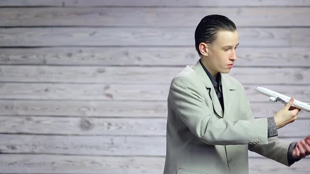 Young businessman playing with a toy plane