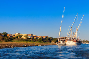 Felucca boats moored near the shore of Nile river in Luxor, Egypt