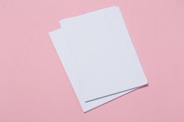 top view of a open notebook on a pink background.