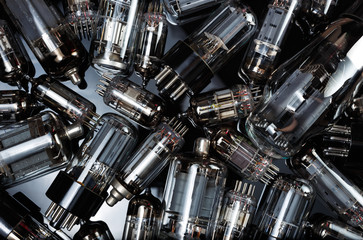 Electronic vacuum tubes on the dark mirror background. Old electronic radio components. 