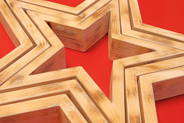 Star, the wooden figure. Three star shapes stacked together like a Pyramid on a red background....