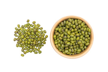 Mung beans in a small wooden bowl and a pile next to it seen directly from above and isolated on white background