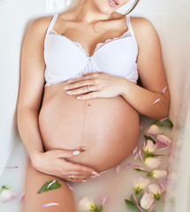 pregnant girl in a milk bath with flowers