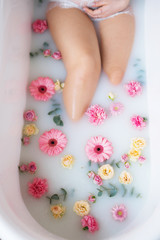 pregnant girl in a milk bath with flowers