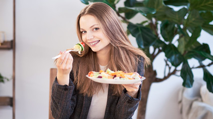 Woman in office eating salad at working place. Concept of lunch at work and eating healthy food. healthy eating concept. business woman in a jacket having lunch at the office