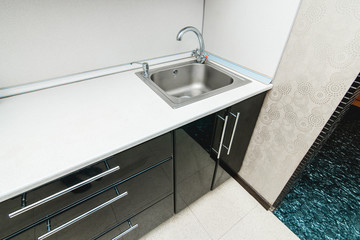 The photo of a sink in a The photo of a sink in a  kitchen