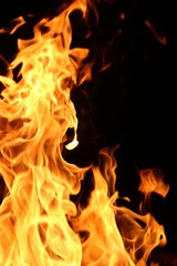 Closeup of a large fire. Wooden planks to the fire. The fire is lit in the night.
