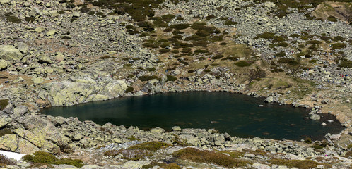 Small glacial lake, of glacial origin, high mountain in spring. Natural Park of the Sierra de Guadarrama, Madrid, Spain