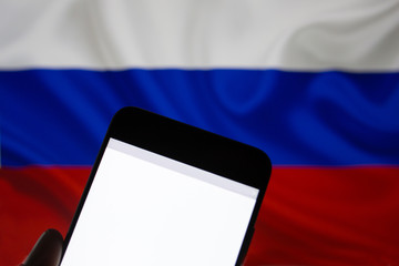 Smartphone with a blank white screen for the inscription on the background of the Russian flag