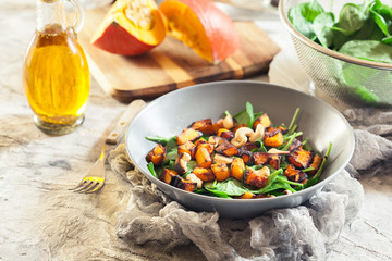 Roasted pumpkin salad with spinach and nuts