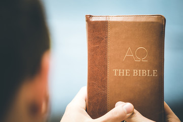 Christian preacher: Young man is holding the bible, praying