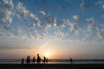 Fototapeta na wymiar Youth playing football at Juhu beach on a summer evening.