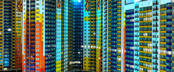 facade of residential apartments in modern metropolis. Night, background texture