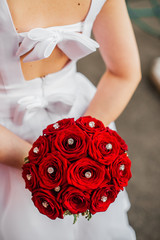 red bouquet behind the girl in a white dress with an open back