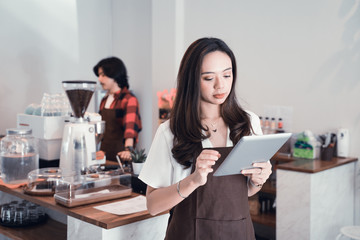 young asian cafe worker with tablet. business entrepreneur