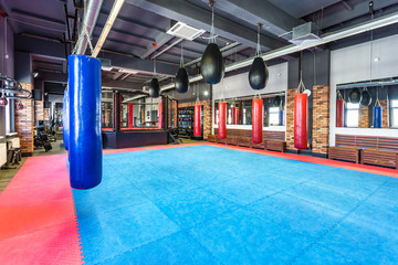 GRODNO, BELARUS - APRIL 2019: Hall of martial arts with fighting ring and punching bags in the...