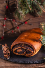 Christmas poppy seeds roll and branch of pine, holiday cake