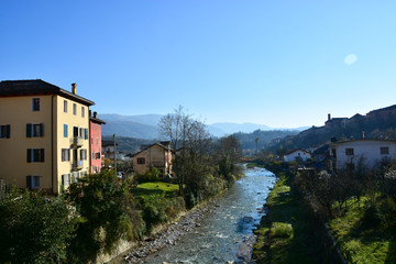Fototapeta na wymiar The Ardo stream slowly descends from the Dolomites and passes through the town of Belluno, Italy
