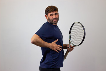 Portrait of handsome young man playing tennis holding a racket with brown hair scared, their back...
