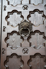 decorative wooden door with lion door knocker of church Cattedrale di San Viglio, Trento, Italy