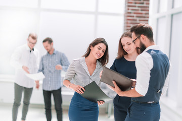 business team discussing business documents, standing in the office lobby