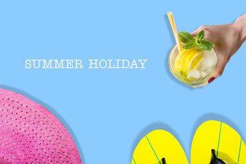 The concept of a summer holiday. Beach slippers, hat and summer cocktail on a blue background. Copy space. View from above. Place for text. Easy to clean text. Summer holiday banner.