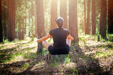 Relaxed Woman Sitting in a Comfortable, Upright Position and Practicing Meditation in the Summer...