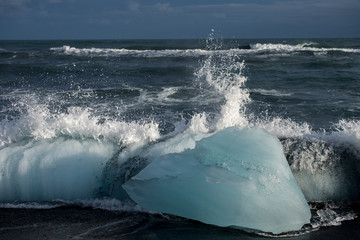 Thaw icebergs on black beach in Jokursarlon shows global warming effect.
