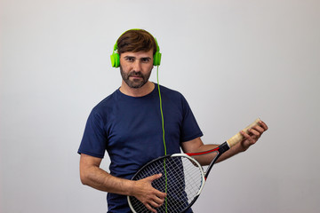 Portrait of handsome young man playing tennis holding a racket with brown hair at a party, looking...